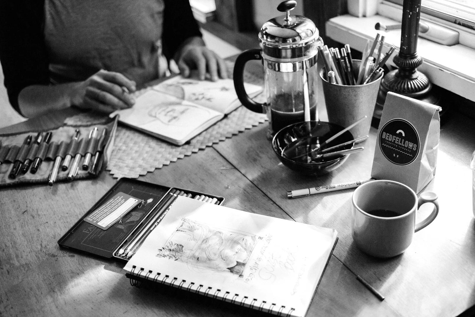 person holding book with sketch. Photograph accompanying Velaharra’s creative project development guide.